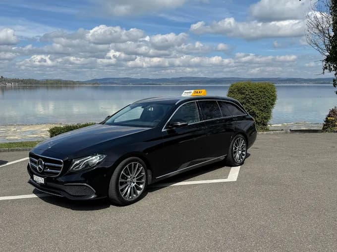 Taxi Thurgi fährt auf malerischer Strasse durch üppige grüne Landschaft.